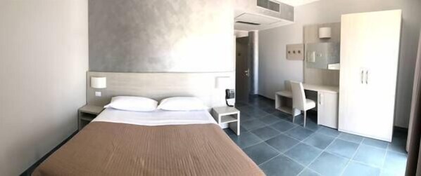 A hotel room with a bed, bedside table, chair, wardrobe, and a small desk. - Hotel Testani Colleferro (Colleferro)