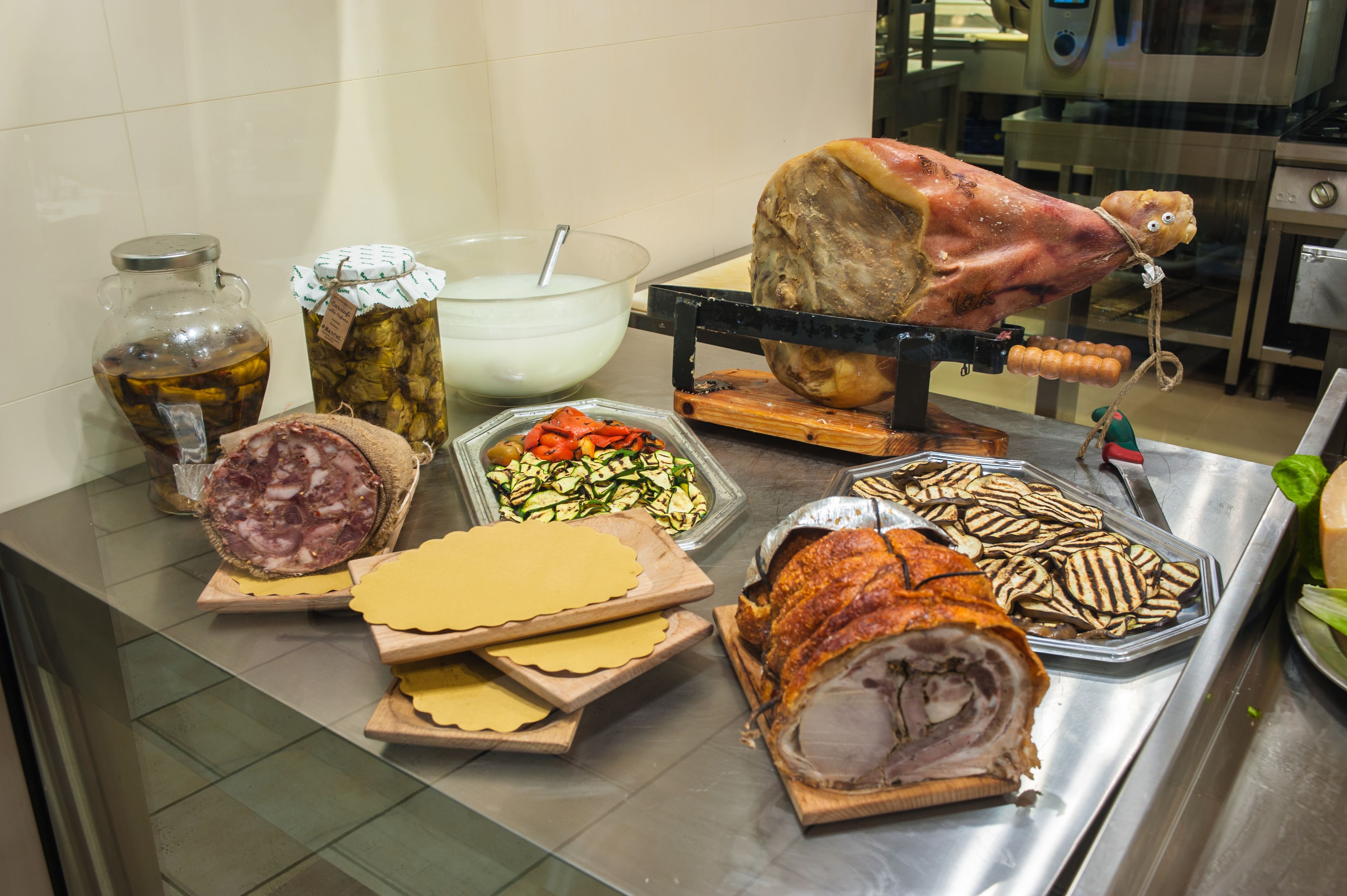 A buffet with various food items including meats, cheeses, and vegetables.
