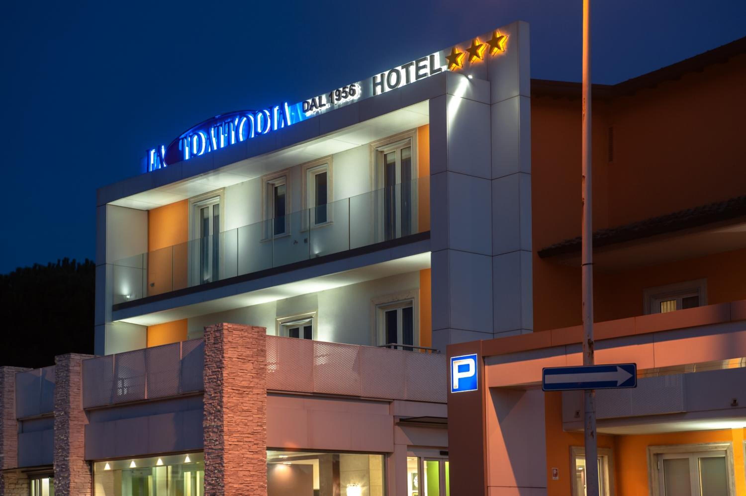 Ein Hotel mit auffälligem Schild, Parkplatzschild und freiem Blick auf den Eingang.