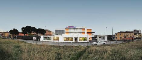 A hotel with a modern design, featuring a two-story structure with a flat roof and a prominent sign.