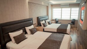 A hotel room with two beds, each with a headboard, a bedside table, and a chair. - Yayla Hotel (Izmir)