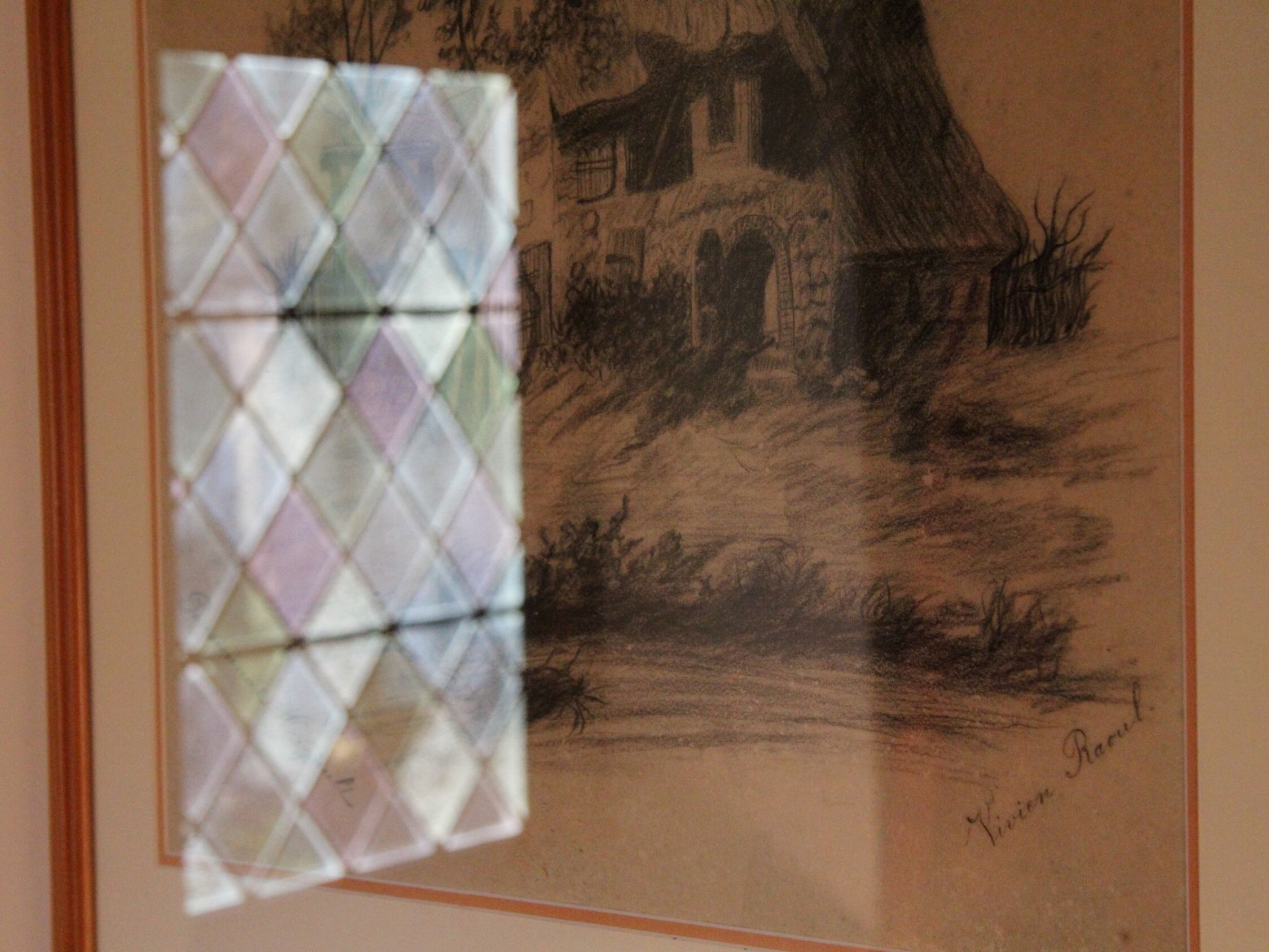 A framed drawing of a building with a signature.