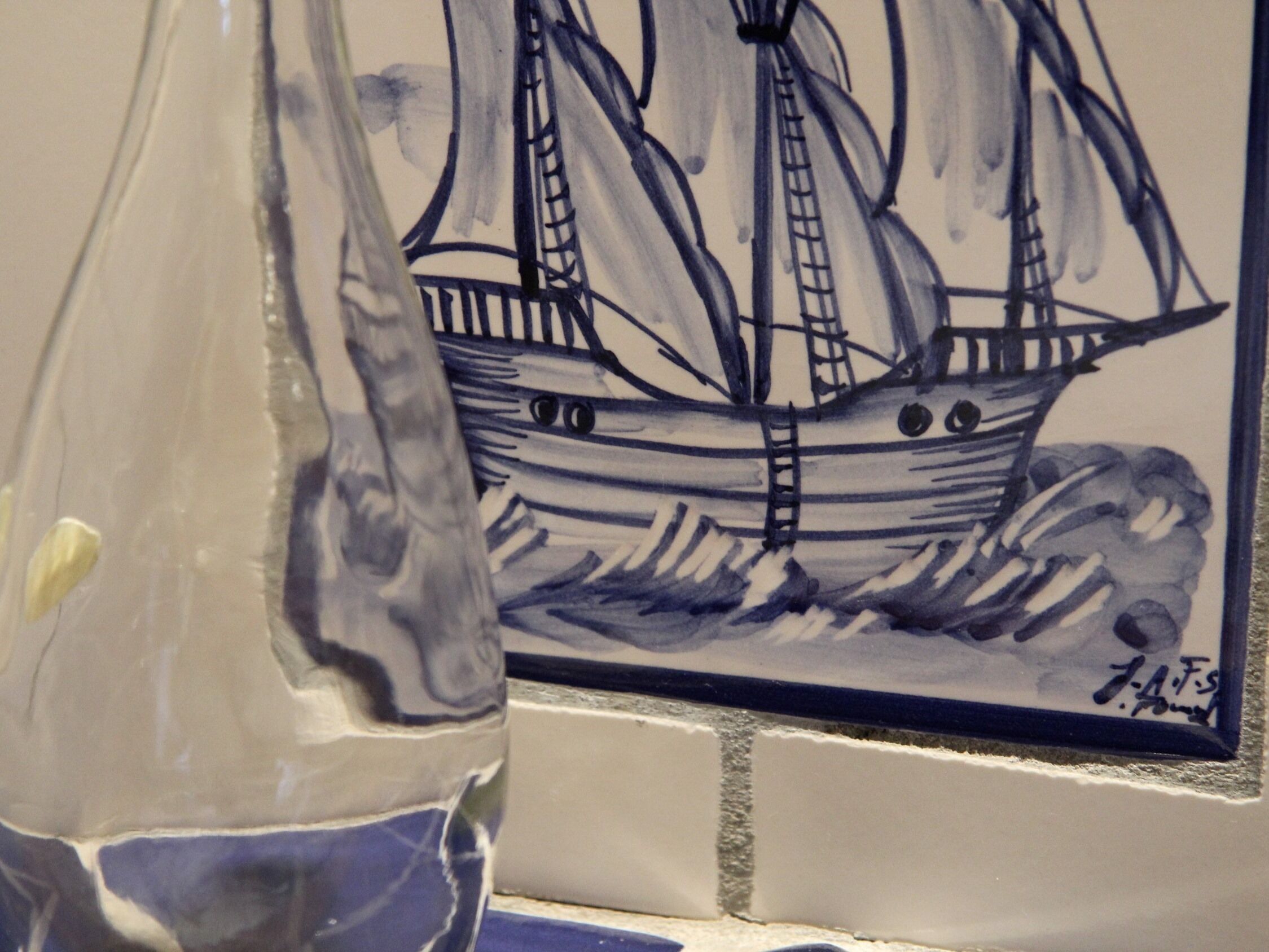 Een keramische tegel met een schip dessin.