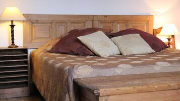 A wooden bed with a headboard, two bedside lamps, and a patterned bedspread.