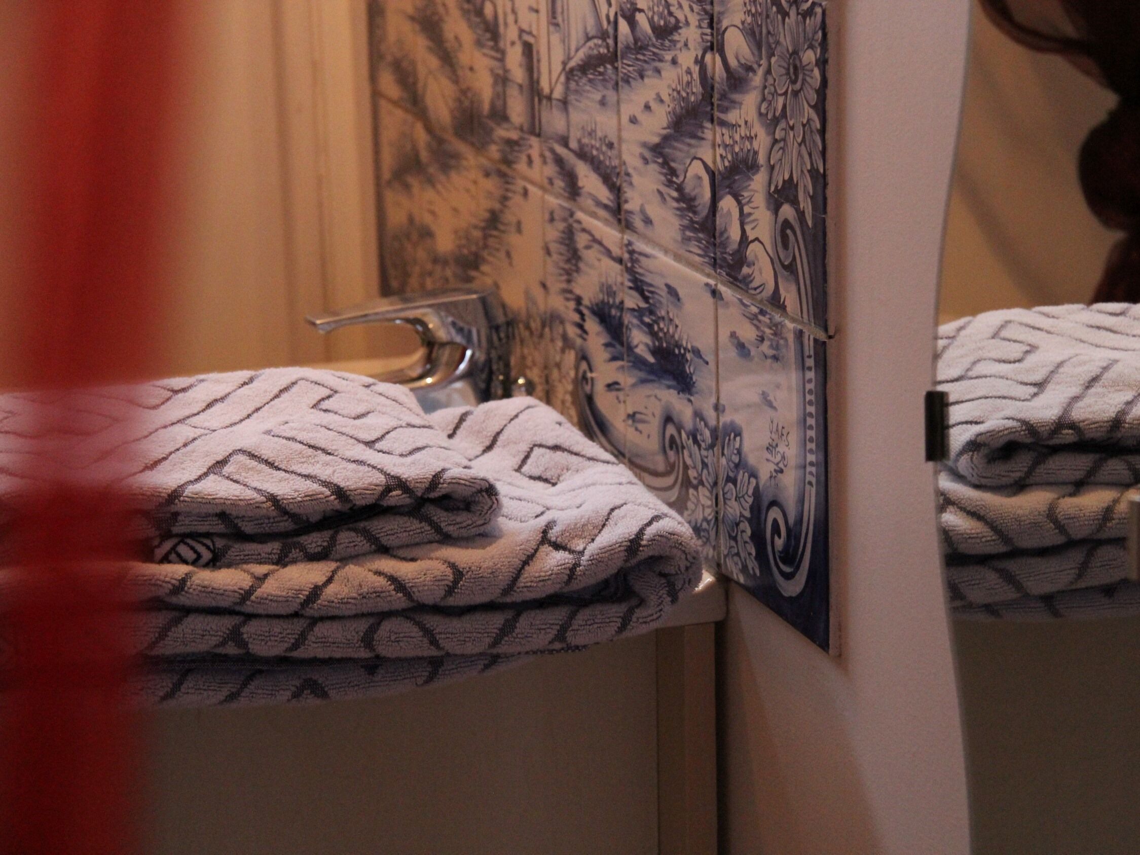 A bathroom with a sink, a mirror, and towels.
