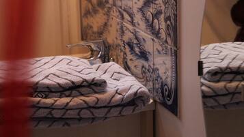 A bathroom with a sink, a mirror, and towels.
