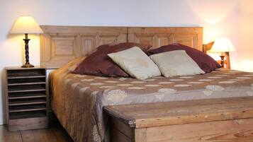 A wooden bed with a headboard, two bedside lamps, and a wooden nightstand with a lamp.