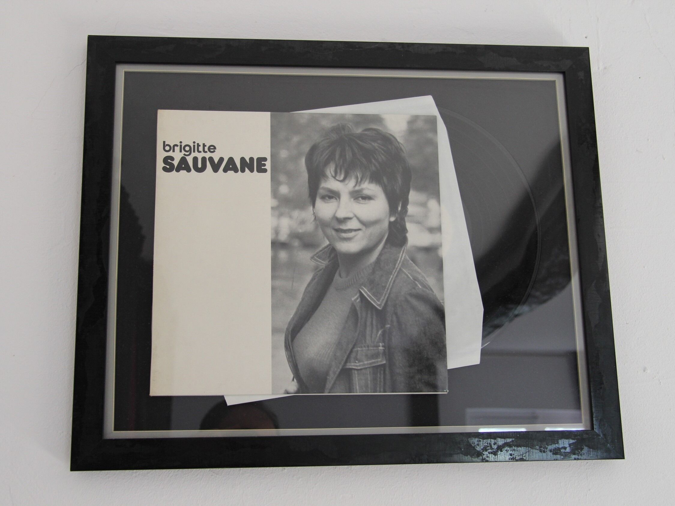Fotografía enmarco con un cartel que dice 'brigitte SAUVANE' y el rostro de una persona.