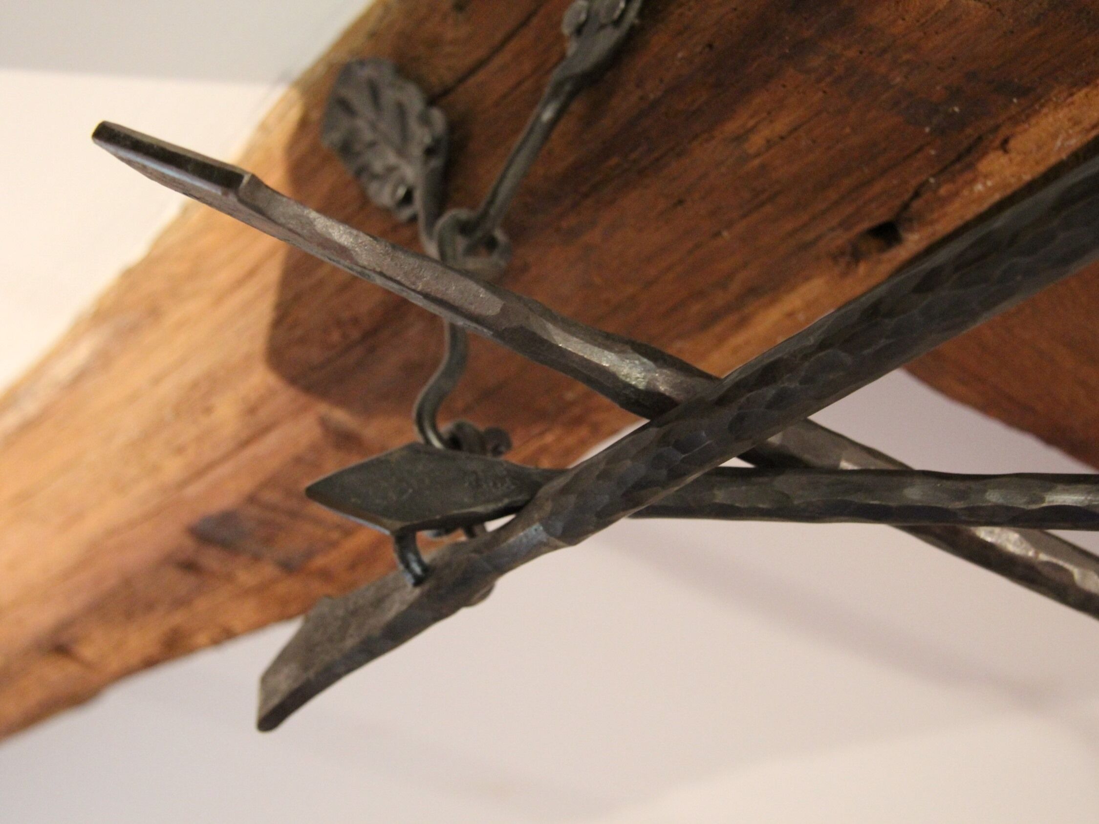 A close-up of a metal sculpture with a rustic wooden background.