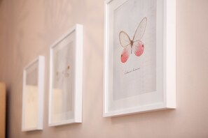 A wall with three framed butterfly illustrations. - CasaNova Guest House (Barcelona)