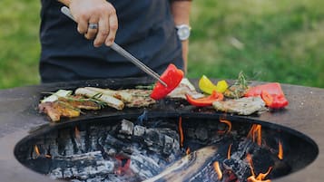 A grill with various meats and vegetables being cooked.