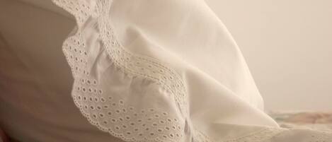 A close-up of a white pillow with a lace trim.
