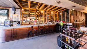 Un bar avec un comptoir en bois, des tabourets et des étagères remplies de bouteilles.