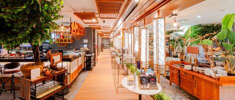 Un restaurante con una barra larga, decoración de madera y plantas en macetas.