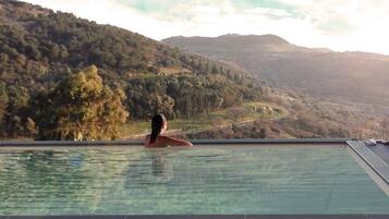 Una piscina al aire libre de temporada, sombrillas