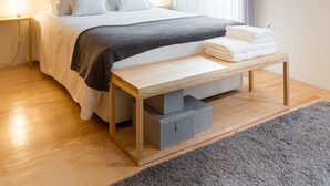 Un dormitorio moderno con cama, mesita de noche, lámpara y equipo de aire acondicionado.