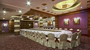 A conference room with a long table, chairs, and a chandelier. - Gargee Grand Patna (Patna)