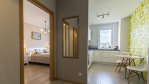 A modern apartment with a bedroom, a dining area, and a kitchen. - Rent a Flat Apartments - Jana Pawla II (Gdansk)