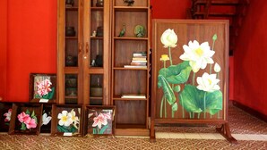 Een houten kast met glazen deuren, een ladder en een lijst met een afbeelding van lotusbloemen.
