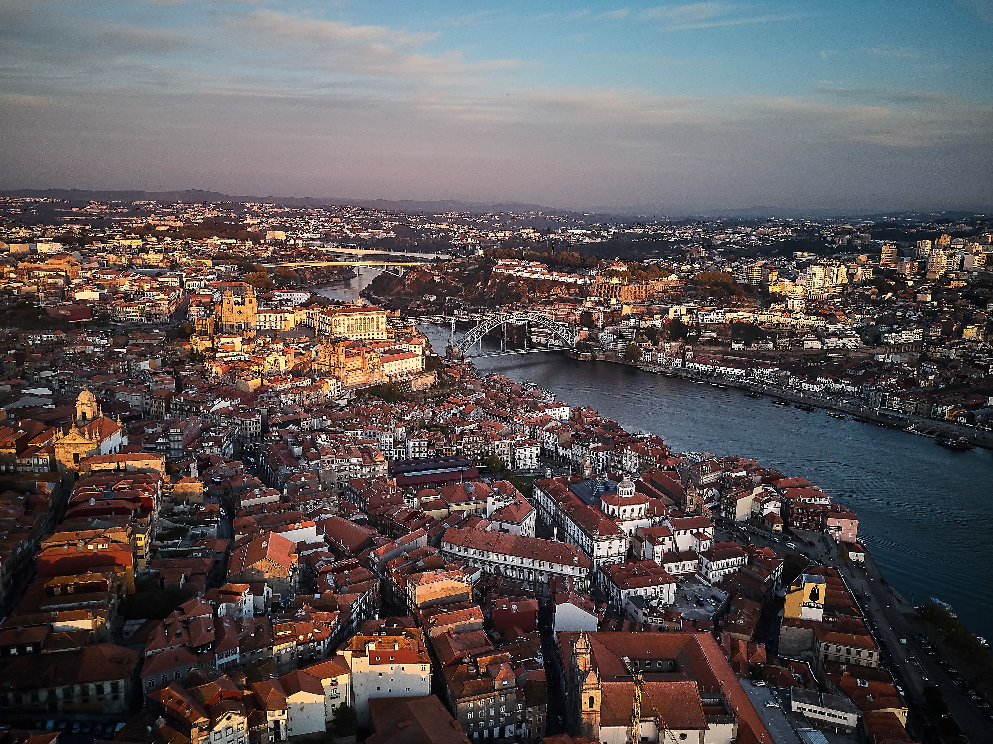 Vista aérea de una ciudad histórica con arquitectura densa, un puente destacado y un río.