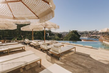 Piscine couverte, piscine extérieure, parasols de plage, chaises longues