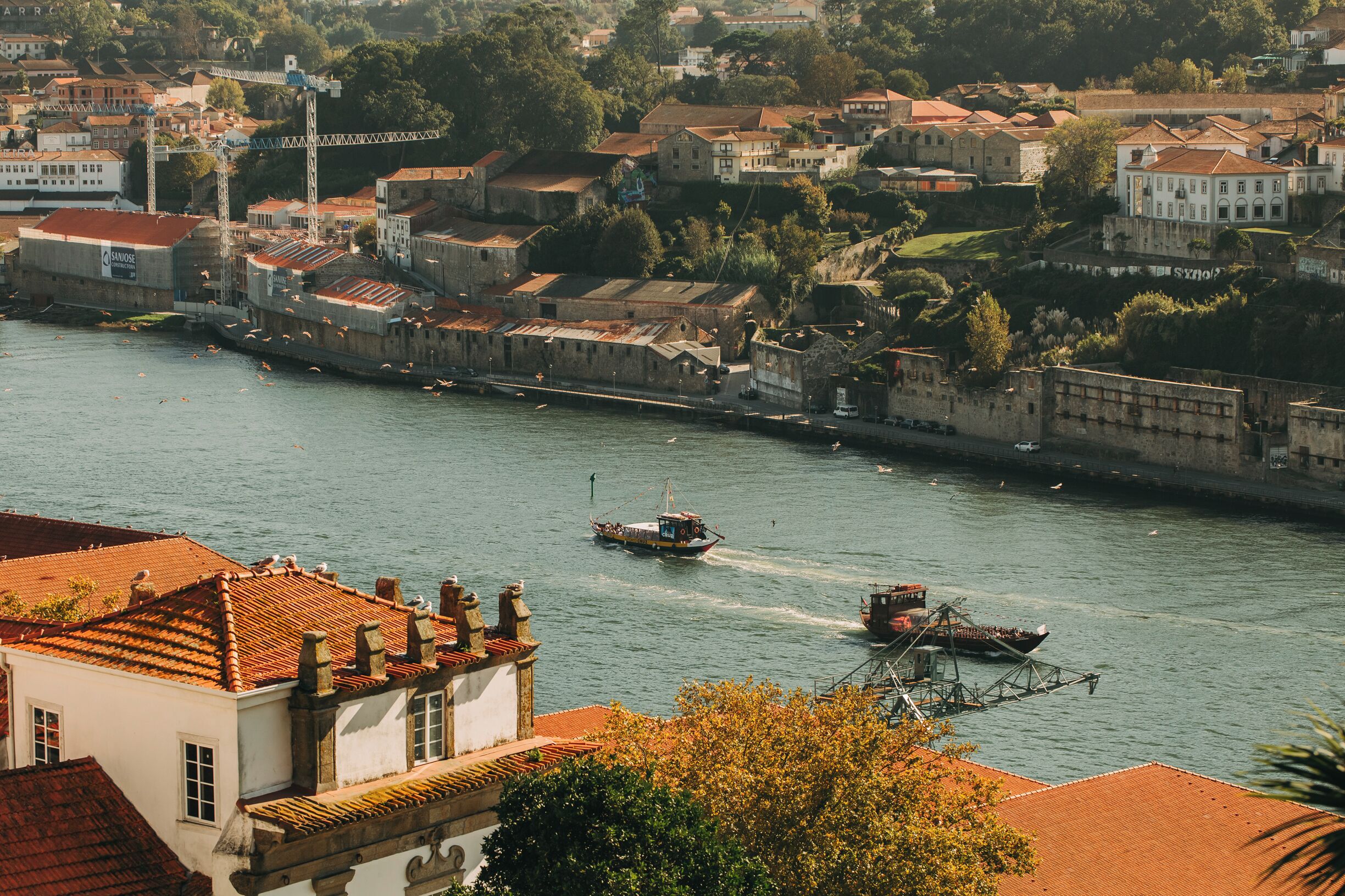 A riverside town with historic buildings and boats on the water.