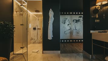 Ein modernes Badezimmer mit einer Duschkabine aus Glas, einem Handtuchhalter und einem wandmontierten Spiegel.