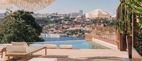 Una piscina cubierta, una piscina al aire libre, sombrillas, tumbonas