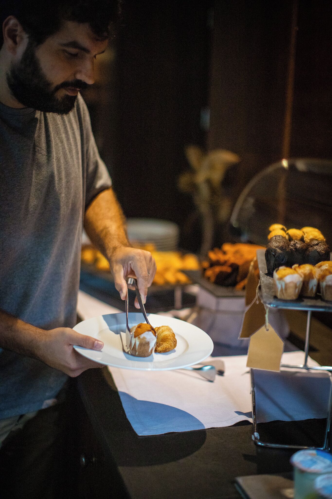 A person serving food from a tray onto a plate.