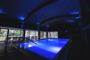 Una piscina techada, sillones reclinables de piscina