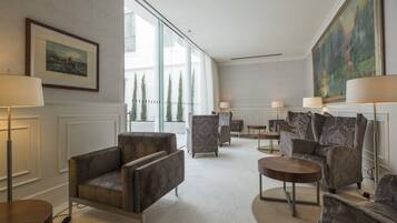A spacious lobby with modern furniture, large windows, and artwork on the walls.