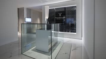 Ein modernes Interieur mit Glastrennwand, Marmorboden und einem Balneari Wellness & Spa Schild.