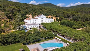 A large building with a swimming pool surrounded by trees. - Hotel Balneari Termes Orion (Santa Coloma de Farners)