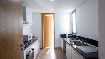 A modern kitchen with a microwave, stove, oven, and double sink.