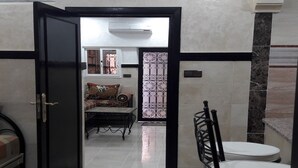 Un interior moderno con comedor que incluye una mesa, sillas, un conjunto de sofás y un panel decorativo.