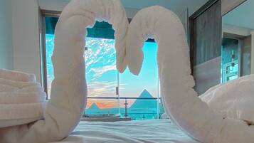 A hotel room with a bed, a large window, and a view of a mountain.