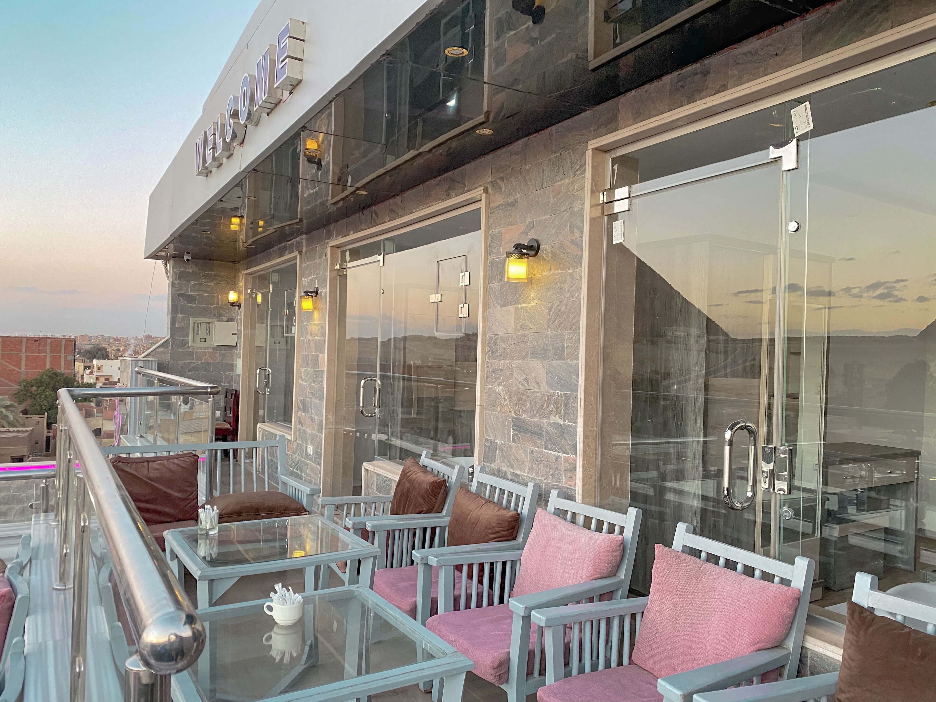 A rooftop terrace with seating and a glass door entrance.