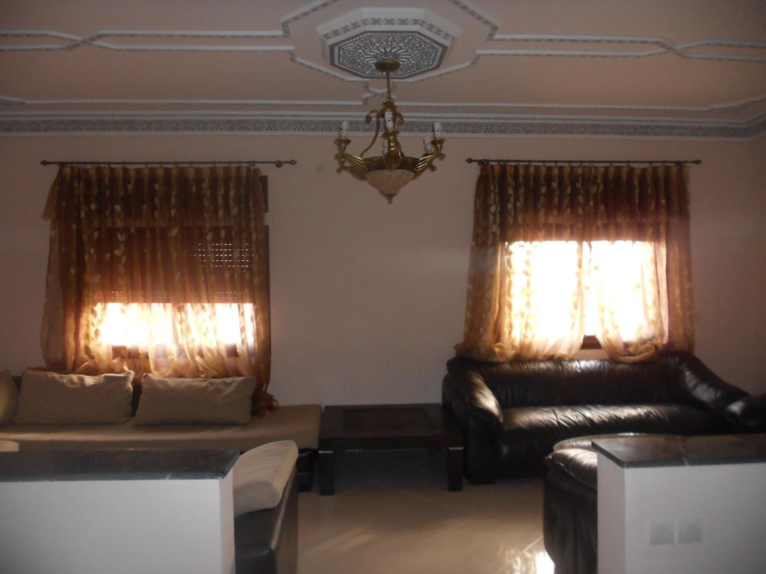 A living room with a sofa, a small table, and a decorative ceiling.