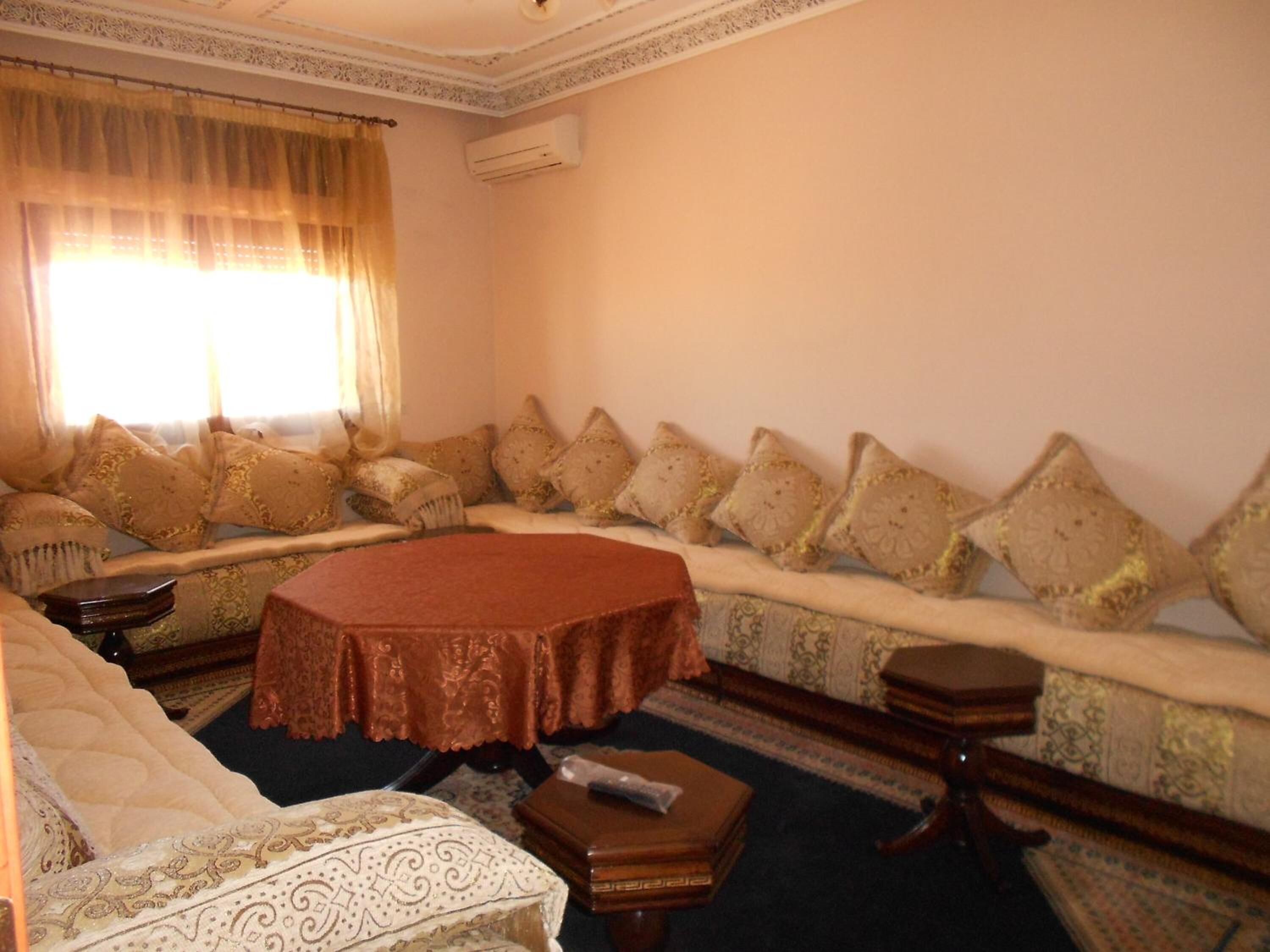 A traditional room with a sofa set, a round coffee table, and a bed.