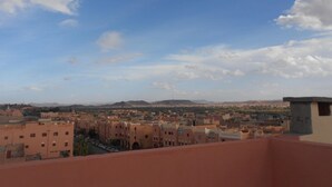 Un paisaje urbano con cielo despejado y montañas a lo lejos.