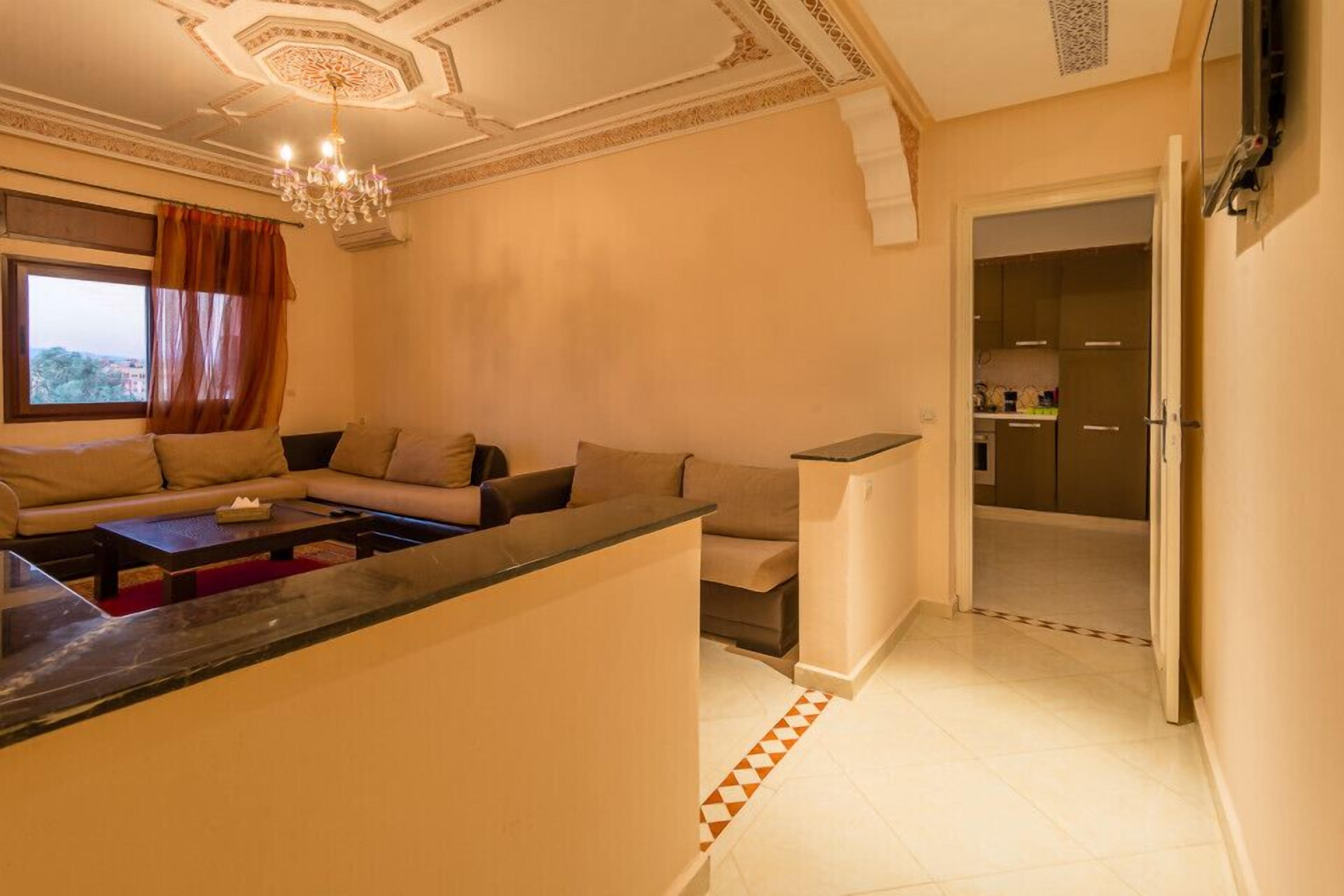 A modern living room with a sofa set, a coffee table, and a TV mounted on the wall.