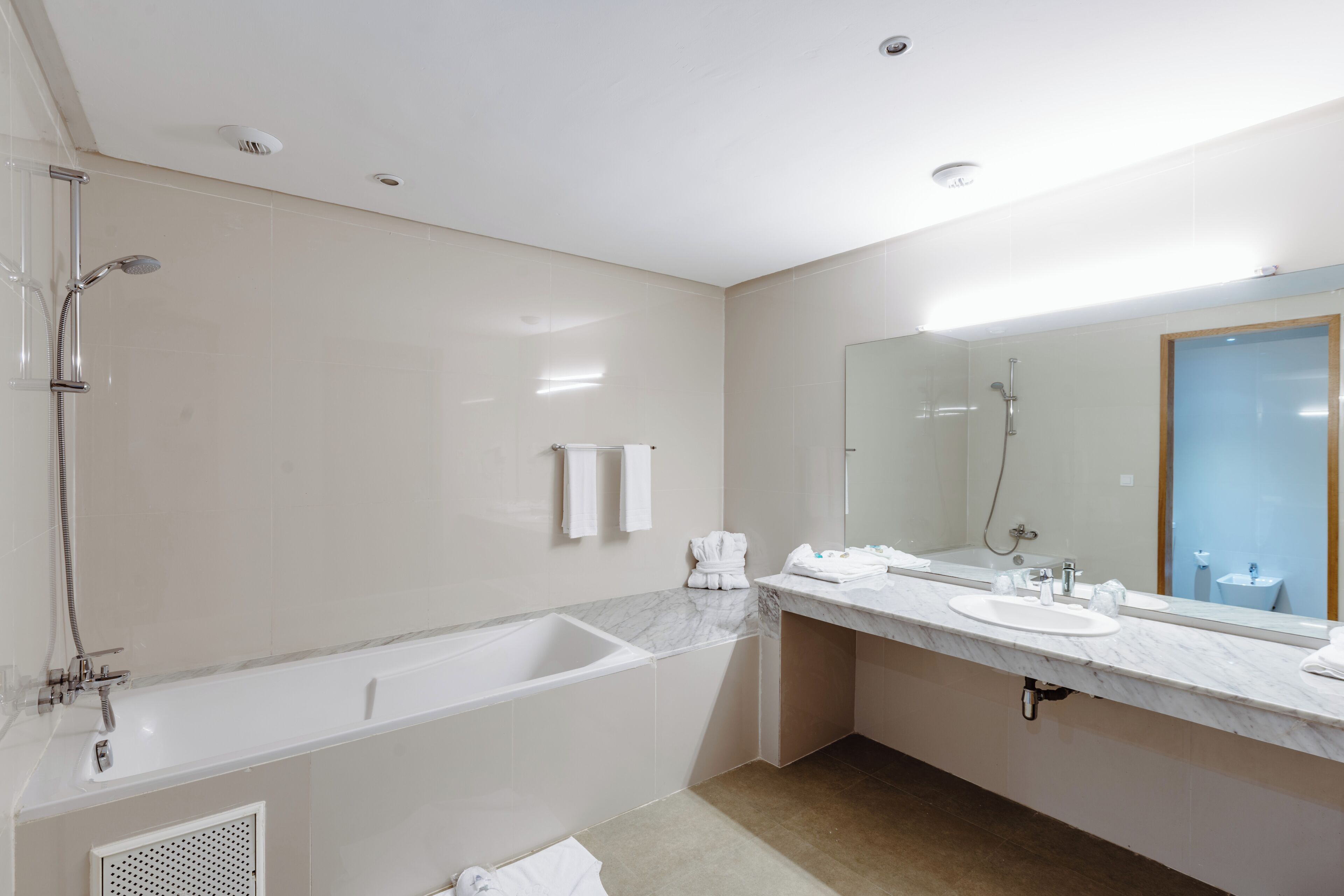 Un baño moderno con bañera, lavamanos, espejo y ducha.