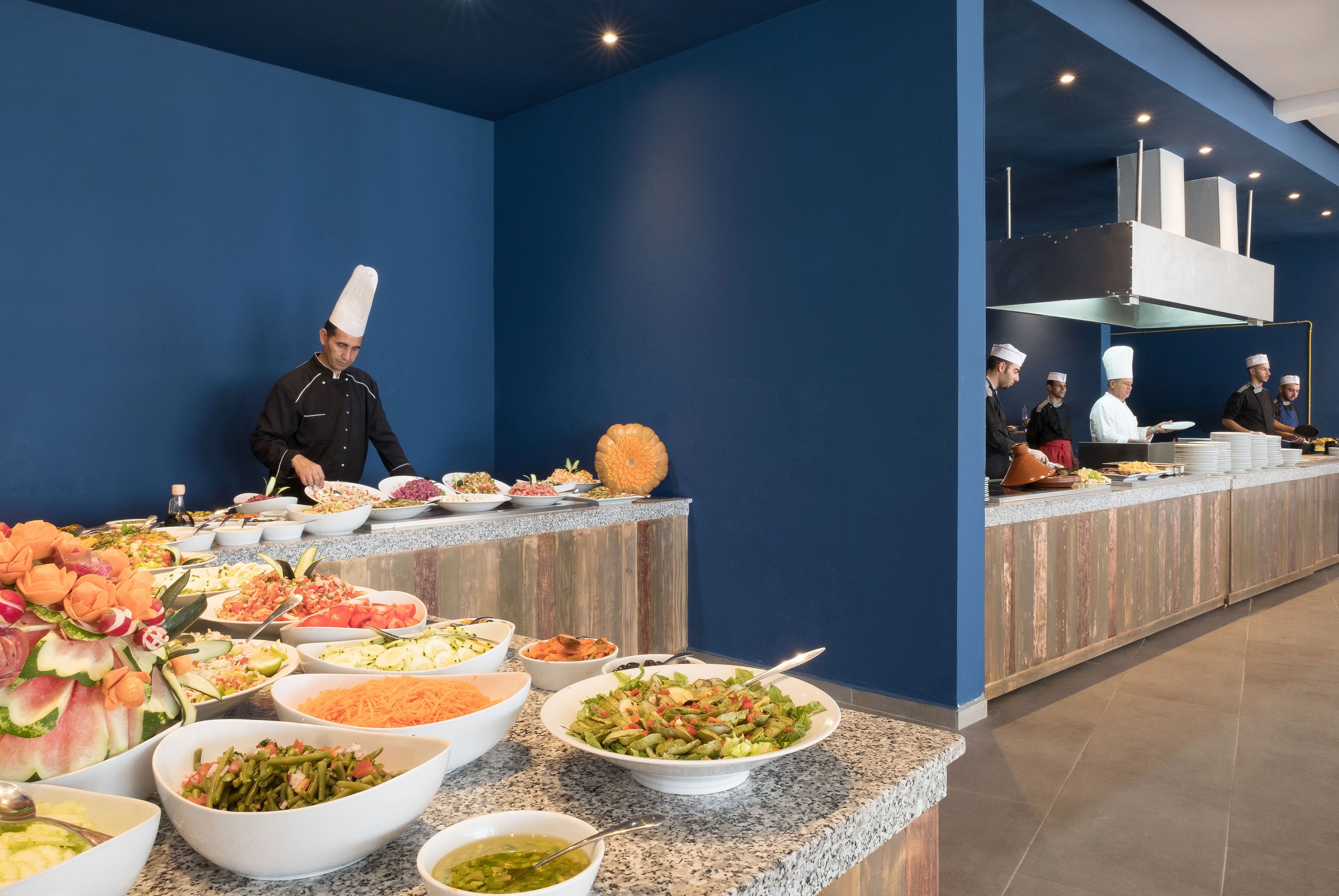 Ein reichhaltiges Buffet mit verschiedenen Speisen und Köchen, die kochen.