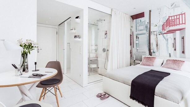 A modern bedroom with a bed, a desk, and a shower area. - Skyreach Bizzstay - Wohnen Am Main (Frankfurt)