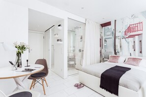 A modern bedroom with a bed, a desk, and a shower area. - VISIONAPARTMENTS Frankfurt (Frankfurt)
