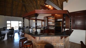 A spacious bar area with a high ceiling, wooden bar stools, and a well-lit interior. - ParkView Lodge (Colchester)