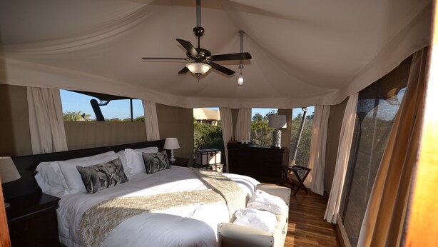 A spacious bedroom with a large bed, a ceiling fan, and a view of the outdoors. - ParkView Lodge (Colchester)