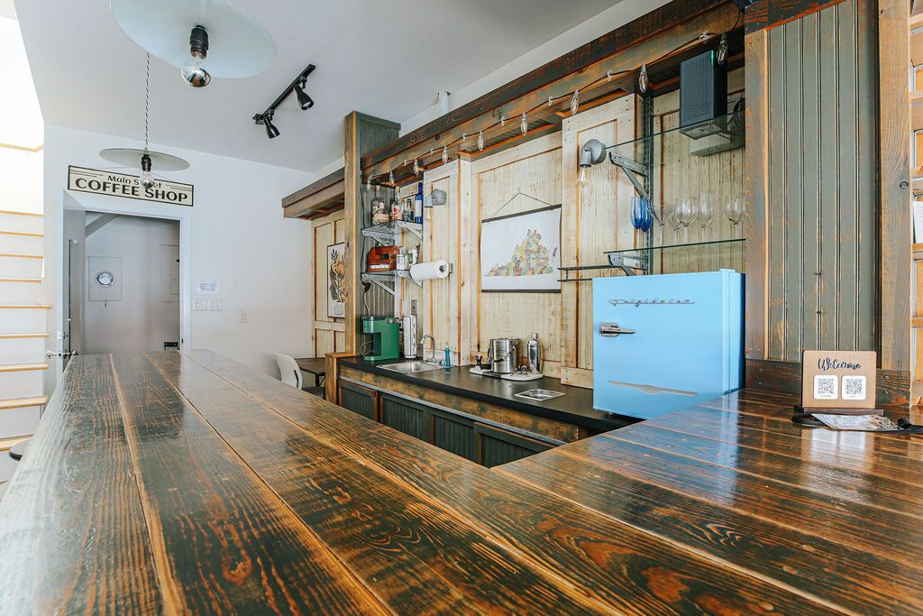 A coffee shop with a wooden counter, a blue refrigerator, and a sign reading "Welcome".