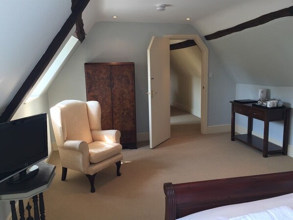 A bedroom with a bed, a chair, a TV, a wardrobe, and a desk. - Castle Farm House B&B (Market Harborough)