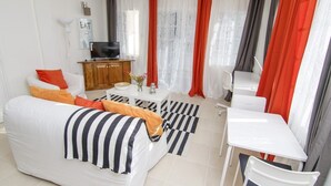 A modern living room with a sofa, coffee table, and a TV. - Ratho Mill Apartments (Ratho Mill)